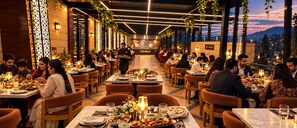 Un restaurante con varias mesas y sillas, un cocinero al fondo y un letrero que dice 'Sky Lounge'.
