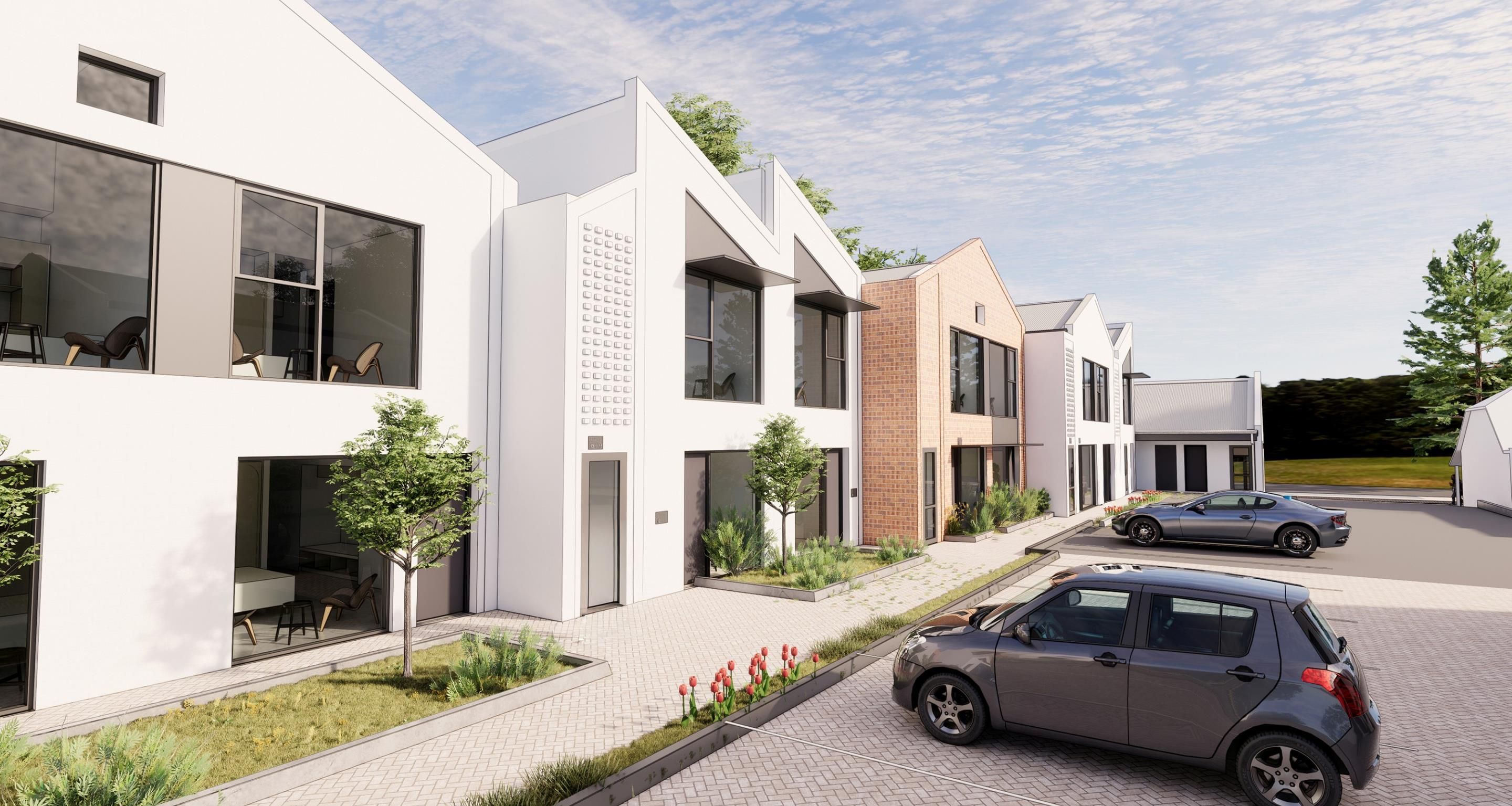 A modern residential building with a brick facade, large windows, and a paved driveway.