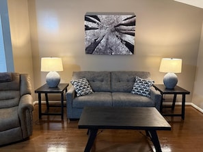 A living room with a sofa, two side tables with lamps, and a coffee table.