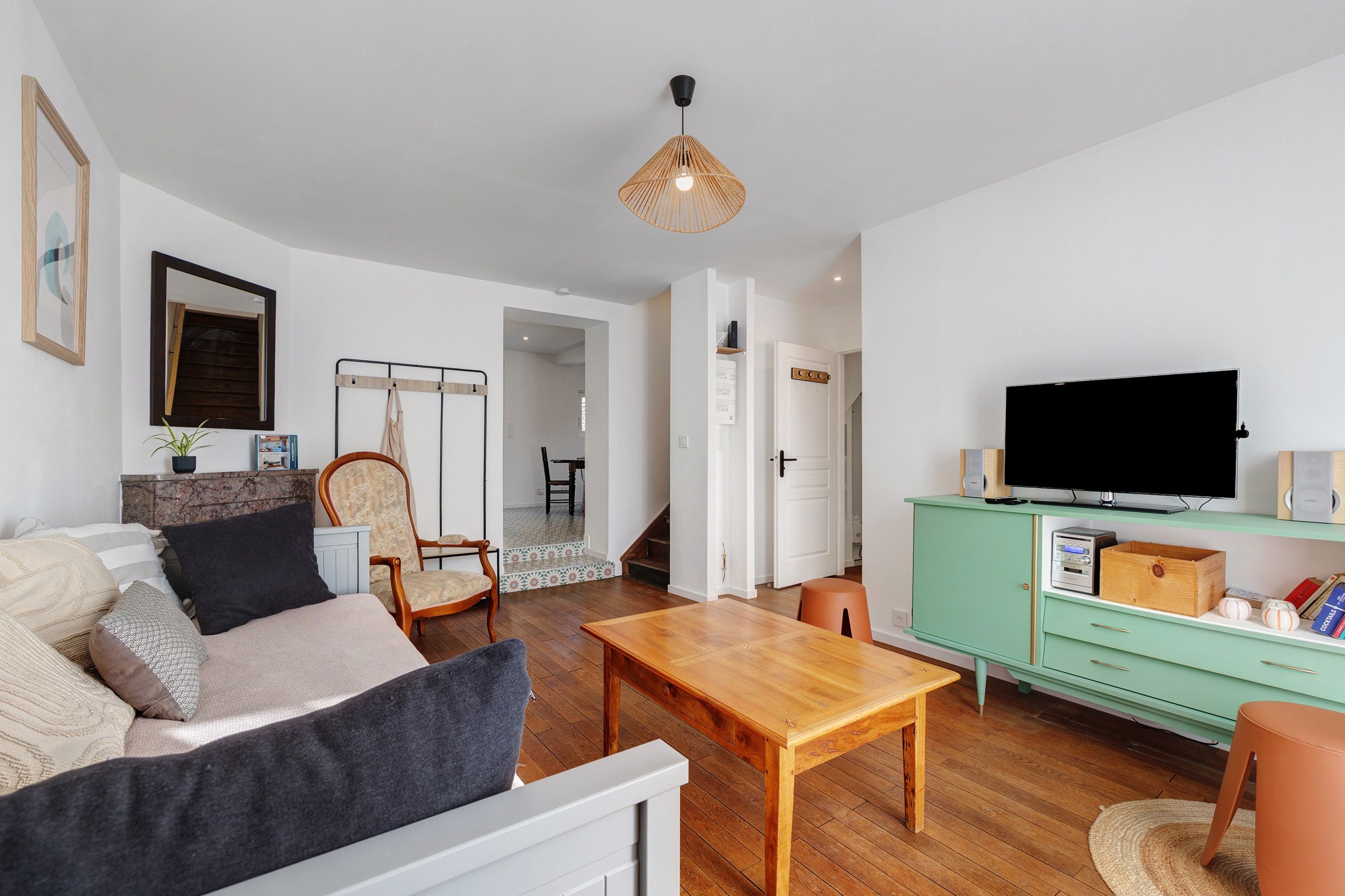 Un salon comprenant un canapé, une table basse, un téléviseur et un meuble.