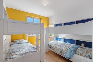A bunk bed room with yellow walls, a window, and a door. - Holiday Home 'Porteau rouge' gîte de la Presqu'île (L'Aiguillon-la-Presqu'île)
