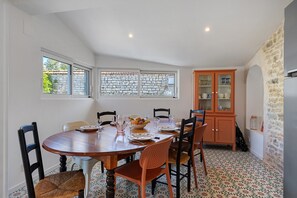 Un comedor con mesa de madera, sillas y un mueble con puertas de vidrio.