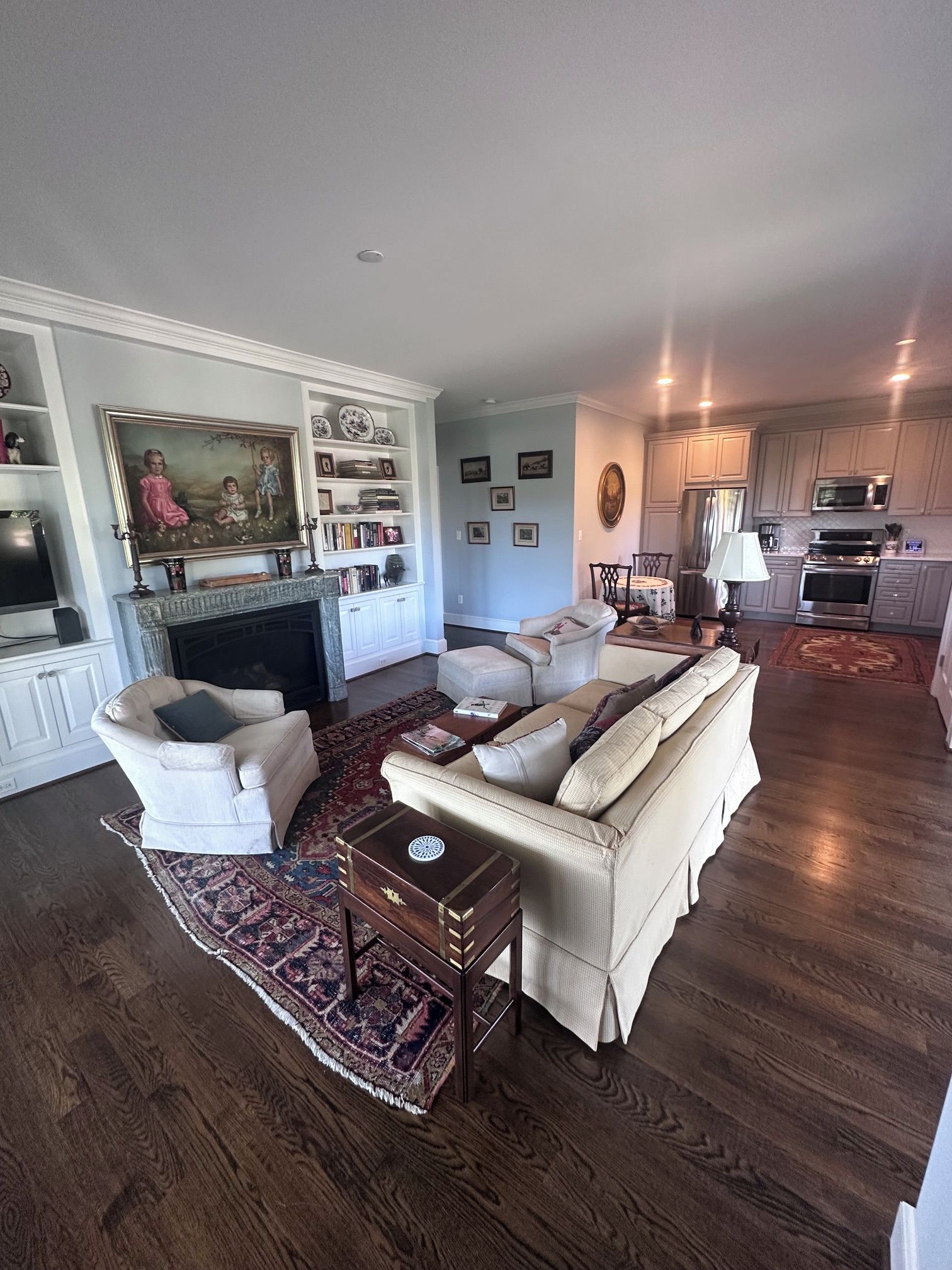Een ruime woonkamer met een open haard, een eethoek en een keuken met moderne apparatuur.
