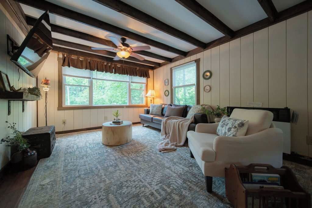 Un salon chaleureux avec une cheminée, un canapé, une table basse et un ventilateur de plafond.