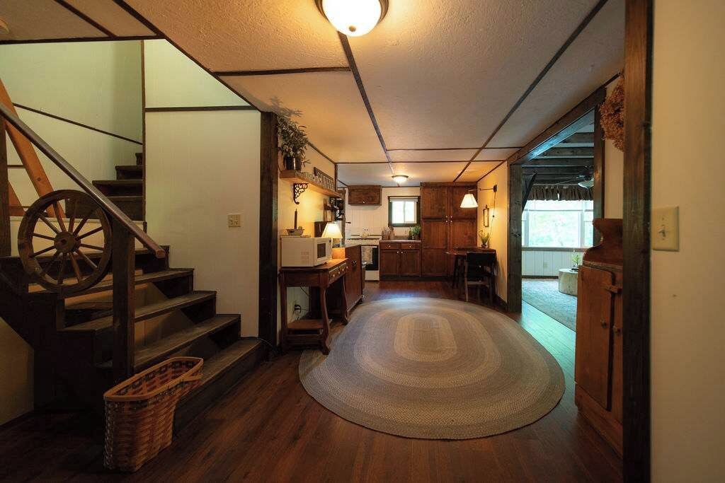 A traditional interior with a wooden staircase, a kitchen area, and a dining space.