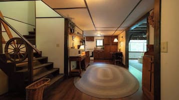 A traditional interior with a wooden staircase, a kitchen area, and a dining space.