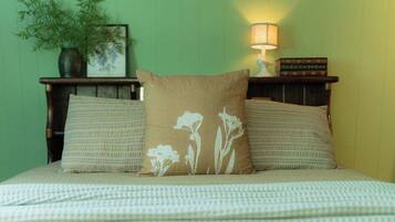 Un lit avec une couvre-lit à motifs et deux oreillers ornés de motifs floraux.