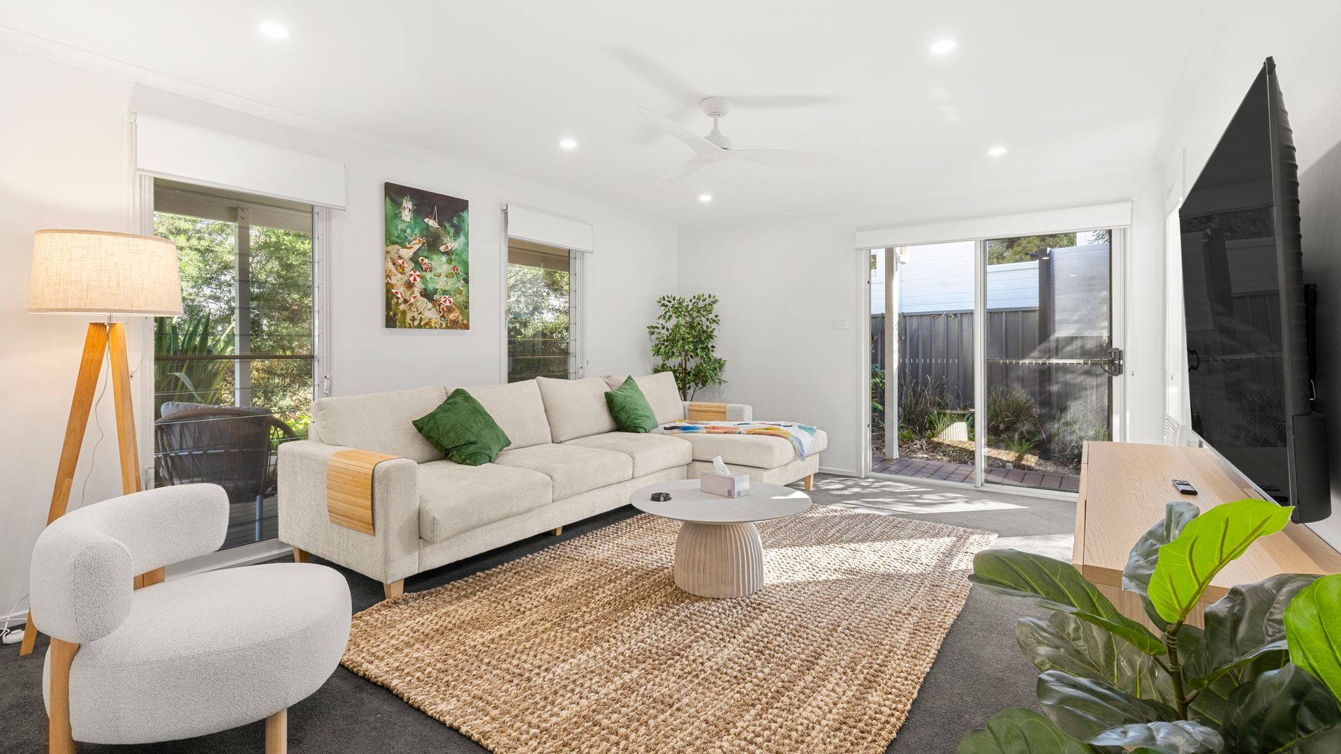 A modern living room with a sofa, coffee table, and a flat-screen TV.