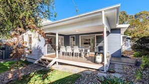 A modern house with a covered patio, a dining area, and a visible kitchen. - Saltwood - Pet Friendly - Community Pool (Callala Beach)