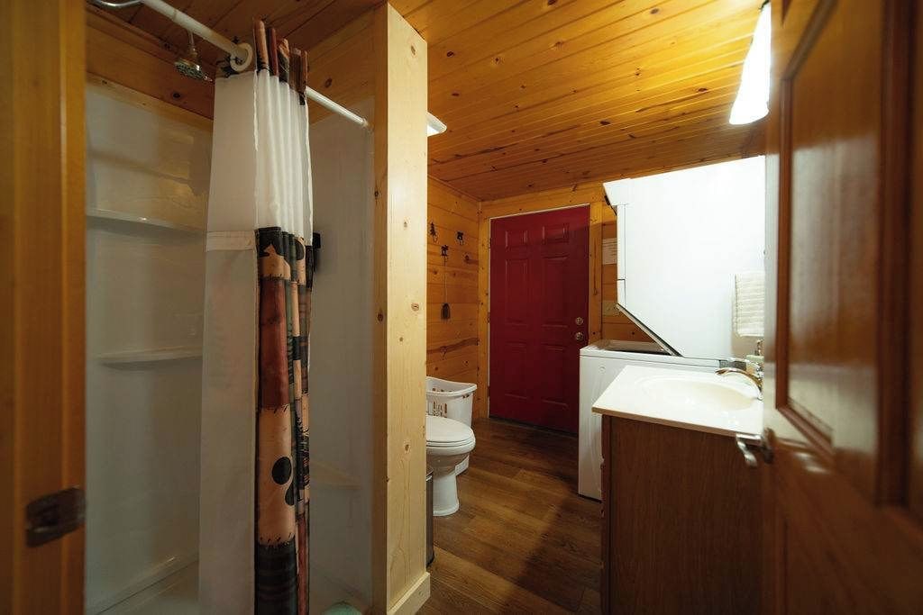 A wooden interior with a shower, toilet, and sink.