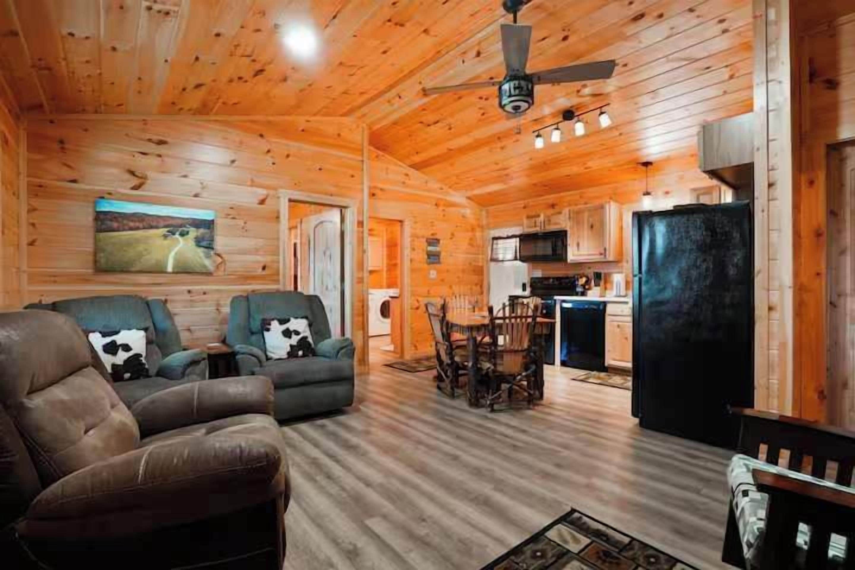 A wooden interior with a sofa, chairs, a dining table, and a kitchen area.