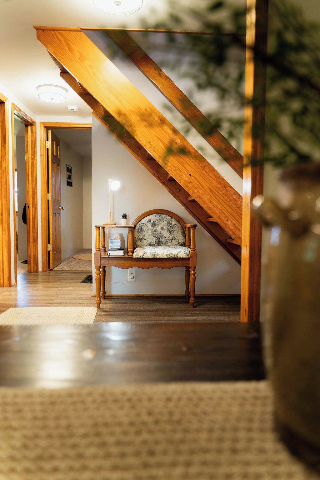 A wooden staircase with a bench at the bottom.