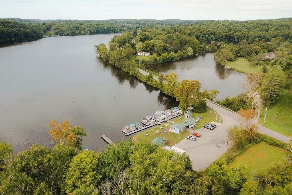 A lakeside property with a dock, RV parking, and a small building.
