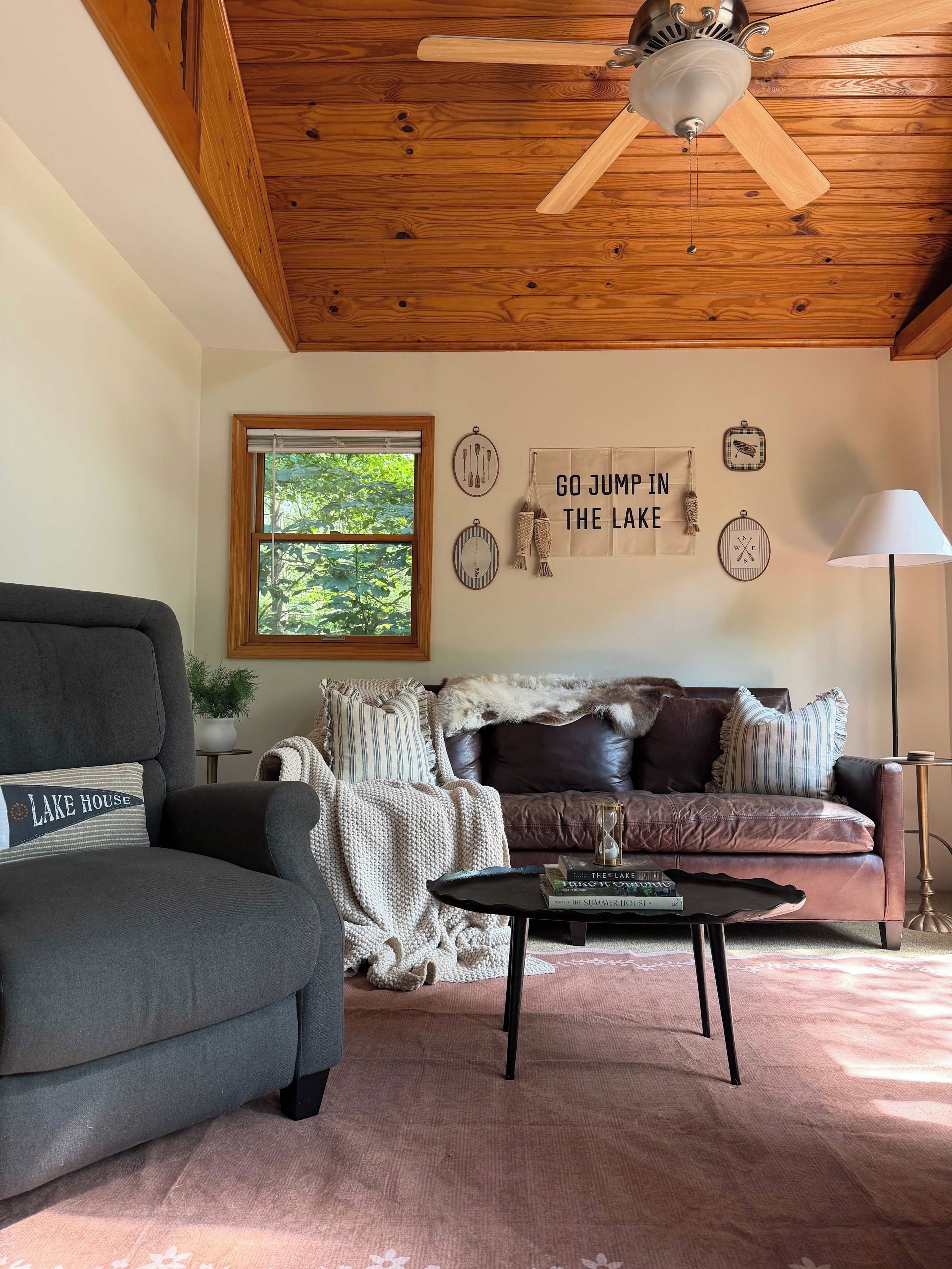 A cozy living room with a grey sofa, a coffee table, and a ceiling fan.