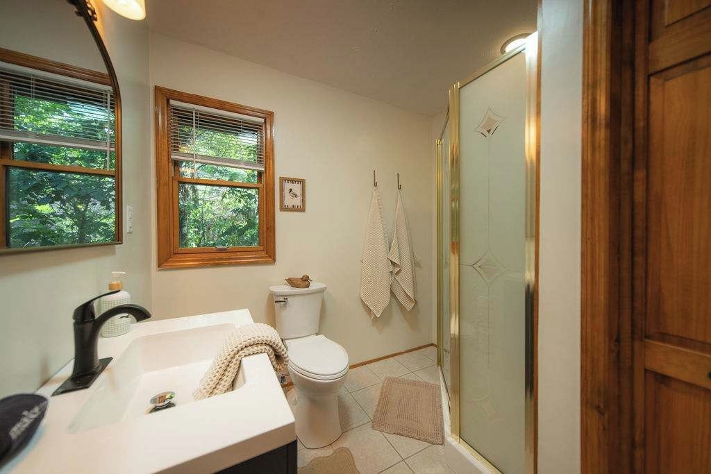 A bathroom with a sink, toilet, and shower area.