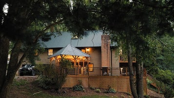 A two-story house with a wooden deck and a covered outdoor area.