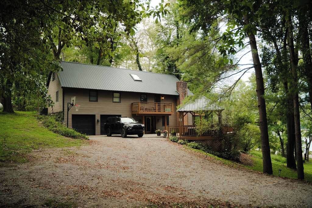 A two-story house with a garage, a covered porch, and a driveway leading to the entrance.