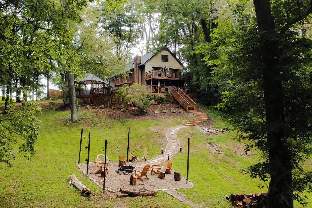 A cabin with a deck and a fire pit area.
