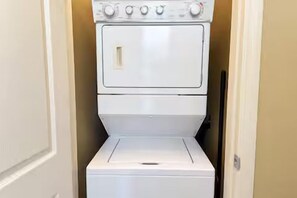 A white laundry machine in a narrow hallway. - Sunset Shores: Waterfront Views + Pool, Branson & Golf Access (Hollister)