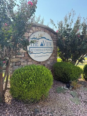 A sign for 'The View at Emerald Pointe' with a stone wall and a clear sky in the background. - Escape to Sunset Shores! Come for the lake, golf or Branson-Stay for the suns... (Hollister)