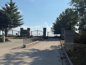 A gated entrance with a sign indicating it is for residents, a paved pathway, and a stone pillar with the word 'RESIDENTS' on it.
