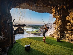 Ein Golfspieler am 3. Loch des Lion's Den, ein 115-Yard-Par-3-Loch, mit Blick auf einen See und Felsen.