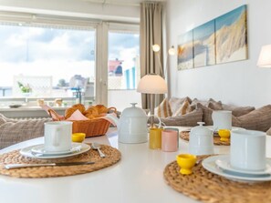 A breakfast setup with a table, breakfast items, and a view of the outside. - 5 - Konigstrasse 5 (Wyk auf Foehr)