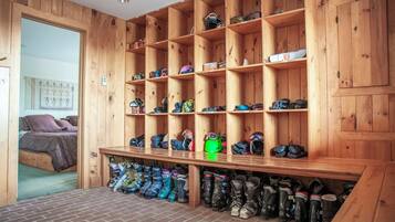 Een kamer met een schoenenrek van hout en een bed.