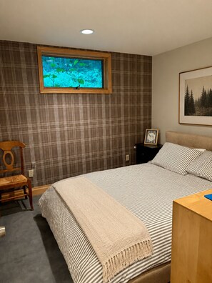A bedroom with a bed, a window with a view of water, a framed picture on the wall, and a wooden nightstand. - Luxury Windham Escape w/ Hot Tub, Views & Walk to Mountain (Windham)