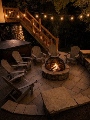 An outdoor patio with Adirondack chairs, a stone fire pit, and a wooden staircase. - Luxury Windham Escape w/ Hot Tub, Views & Walk to Mountain (Windham)