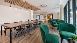 Ein moderner Konferenzraum mit einem langen Tisch, Stühlen und einem Tischfußballtisch.