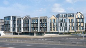 Ein modernes, mehrstöckiges Gebäude mit Flachdach, großen Fenstern und einer symmetrischen Fassade.