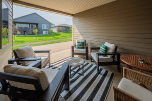 A covered outdoor seating area with a view of a residential building.