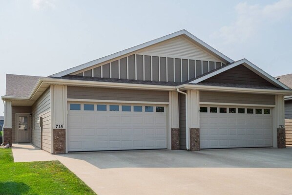 A two-story house with a garage, a front door, and a driveway.