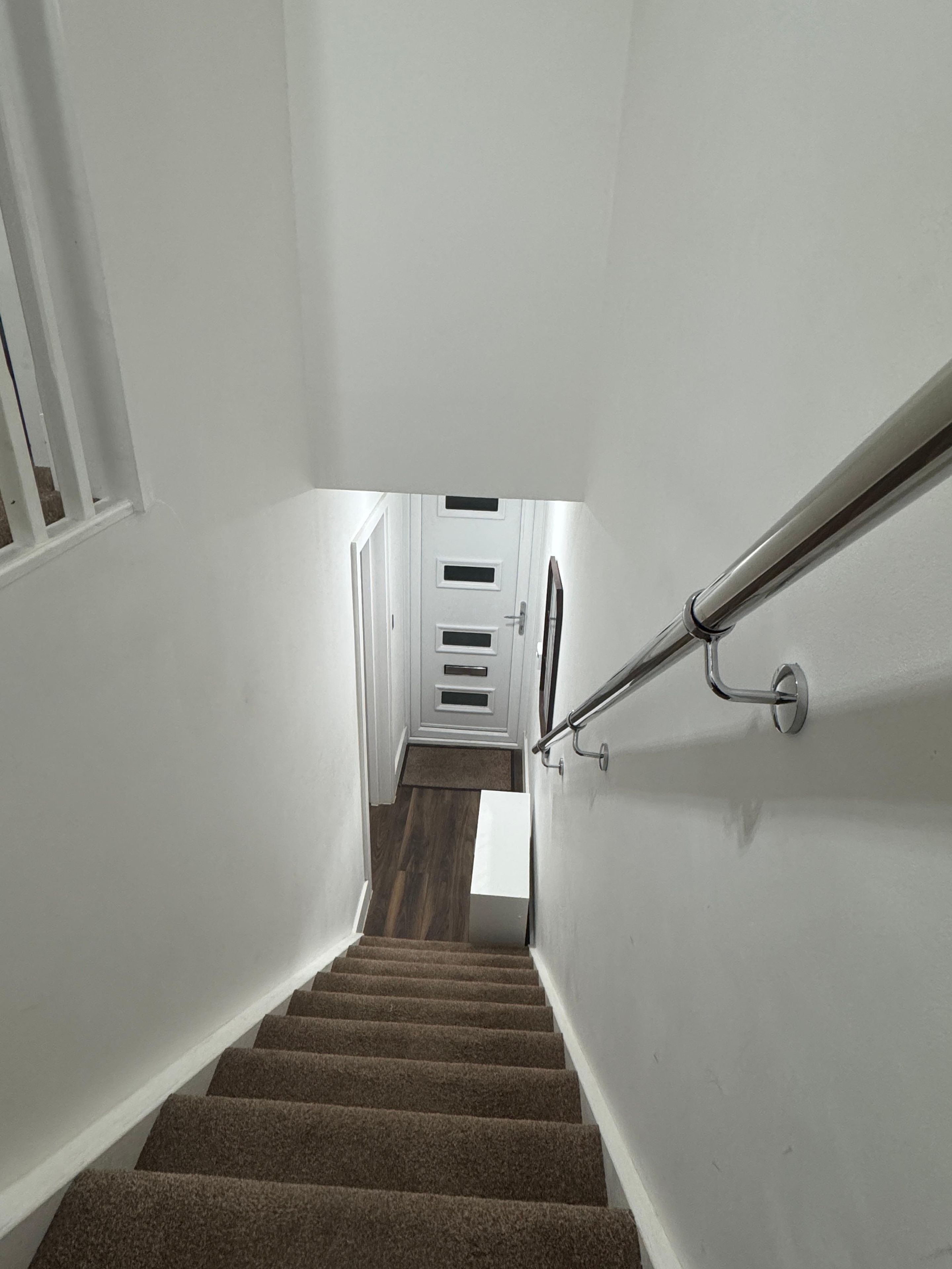 A staircase with carpeted steps leading to a landing with a door.