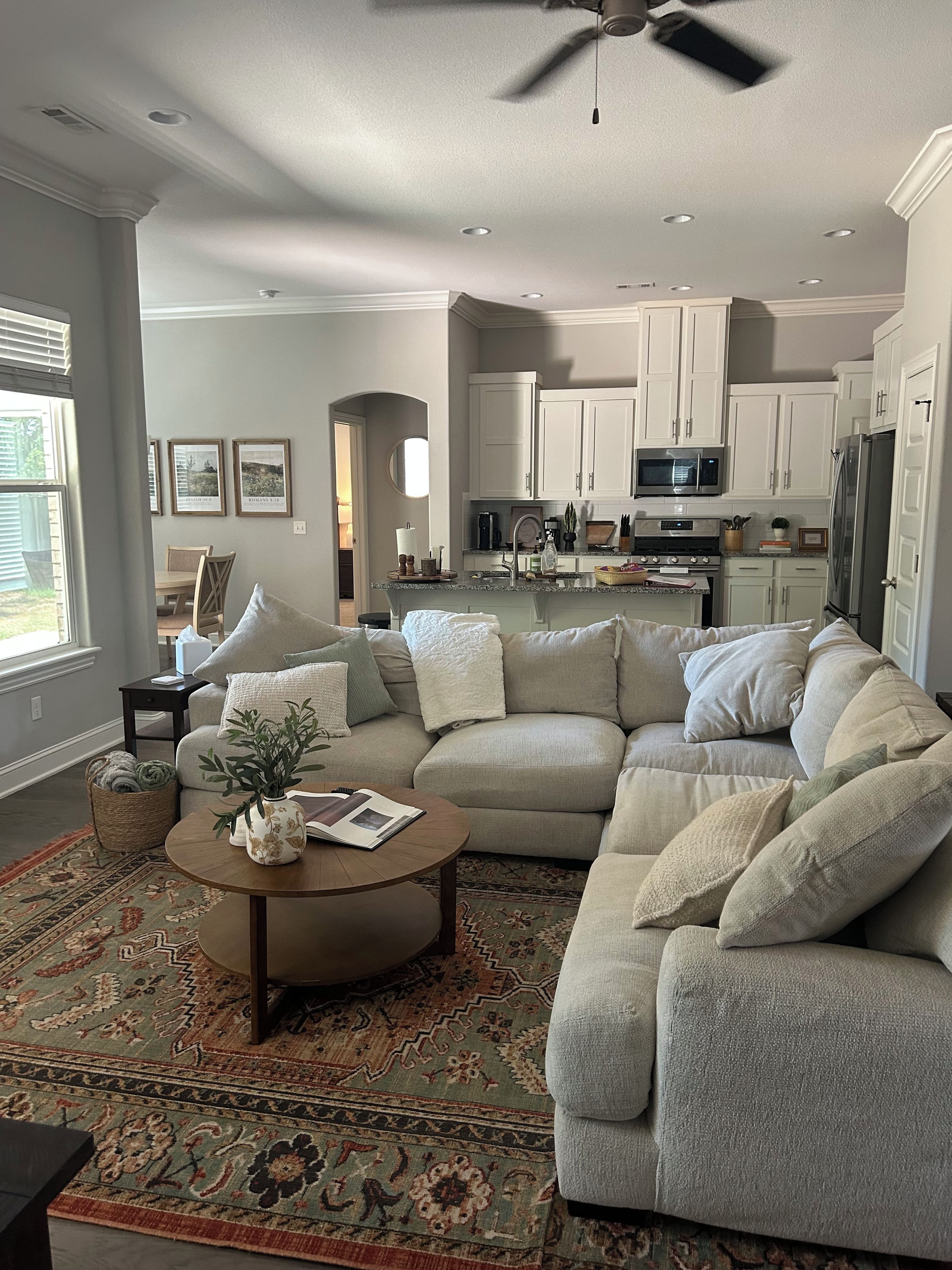 A modern living room with a sectional sofa, a coffee table, and a patterned rug.