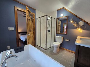 A modern bathroom with a bathtub, toilet, and shower area.