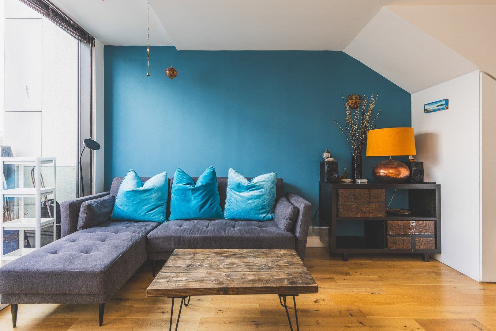 A living room with a sectional sofa, a coffee table, and a side table with a lamp.