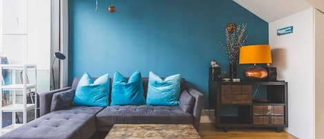 A living room with a sectional sofa, a coffee table, and a side table with a lamp.