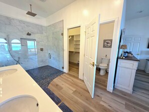 Ein modernes Badezimmer mit einer großen Badewanne, einer Duschkabine aus Glas und Holzboden.