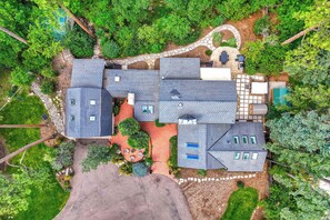 Ein Wohnhaus mit mehreren Gebäuden, einem angelegten Garten und einem Swimmingpool.