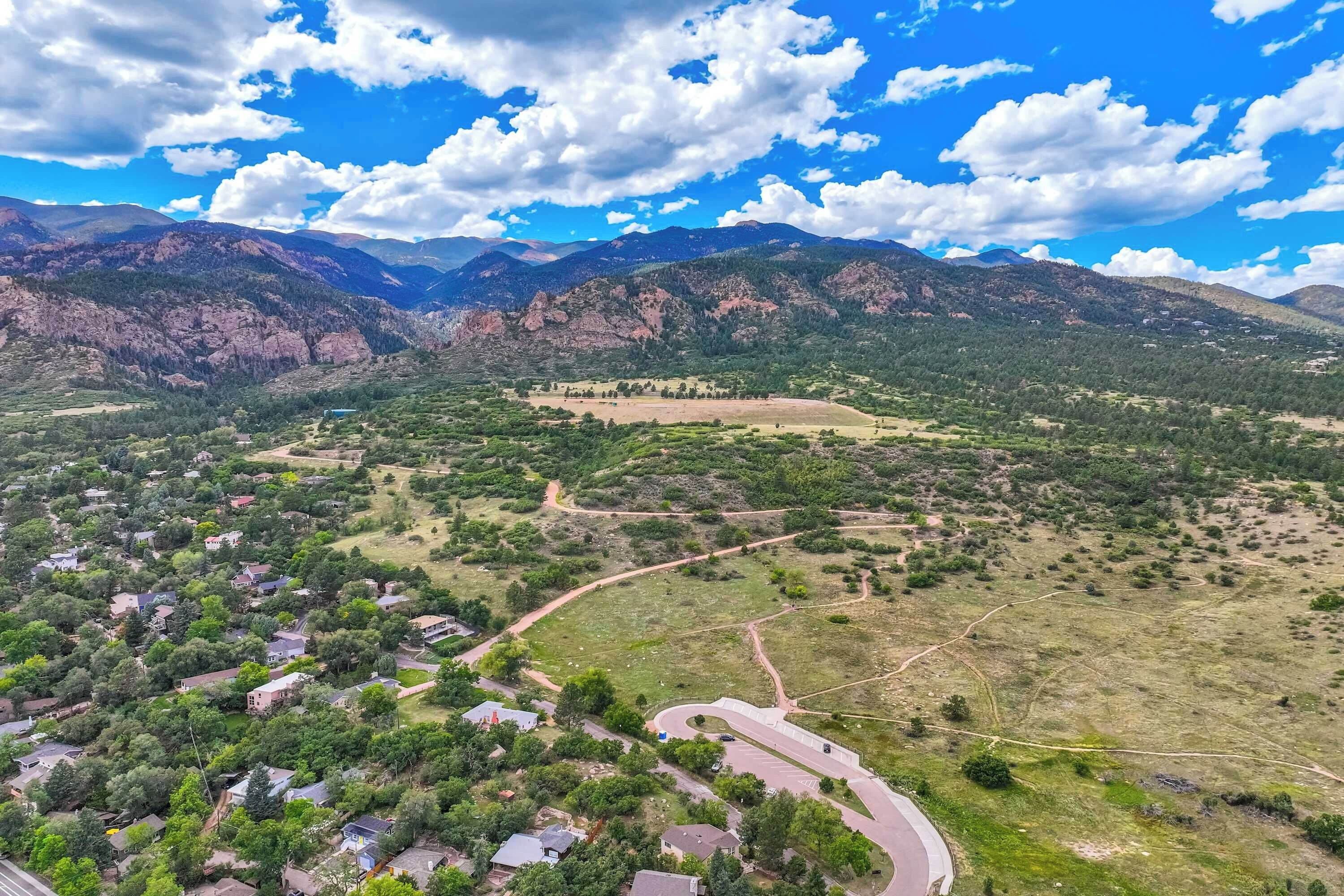 A residential area with houses, roads, and mountainous terrain in the background.