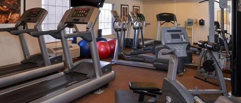 A gym with treadmills, elliptical machines, and weight equipment.
