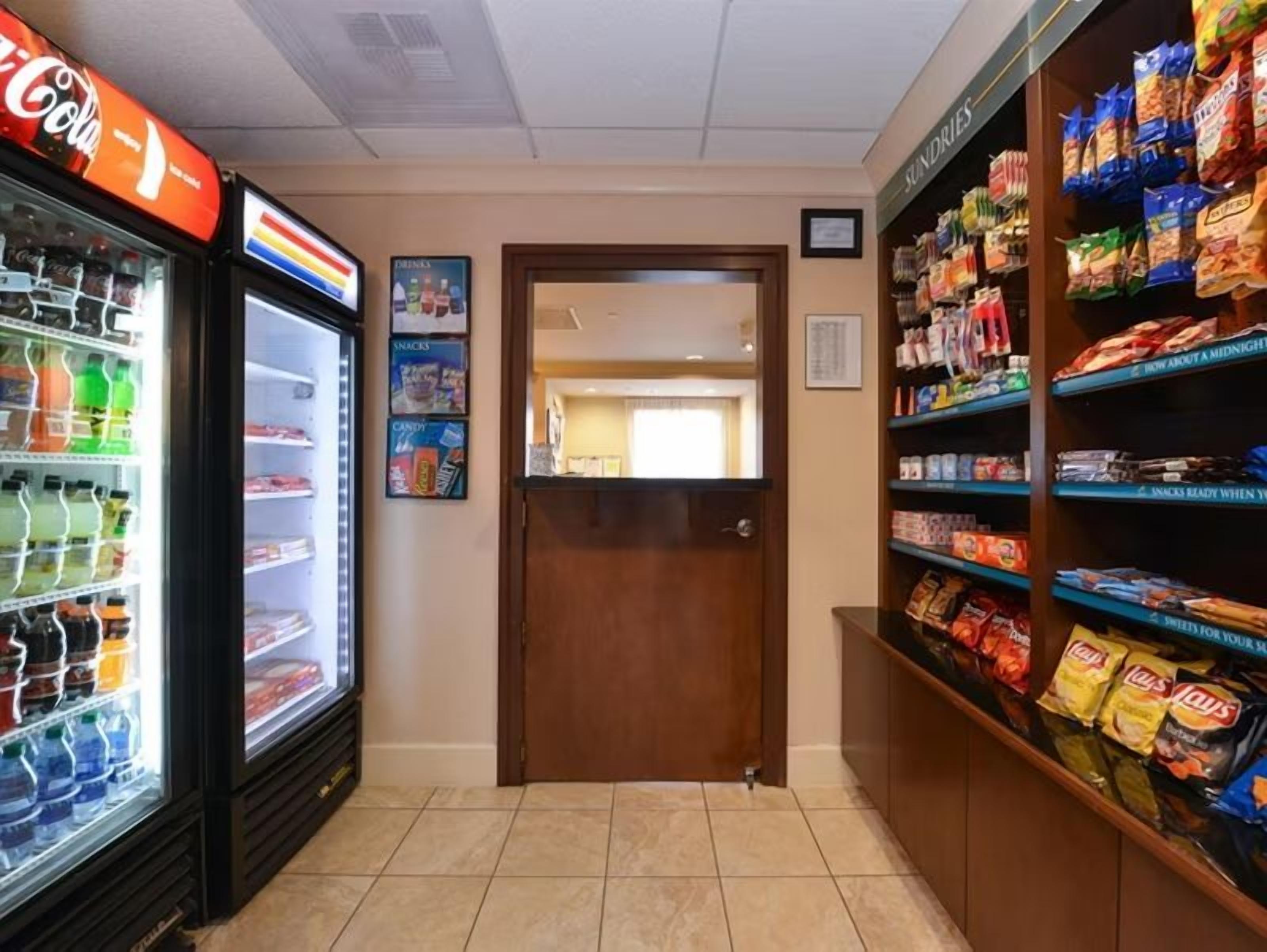 Zona de venta con aperitivos y un refrigerador de Coca-Cola.