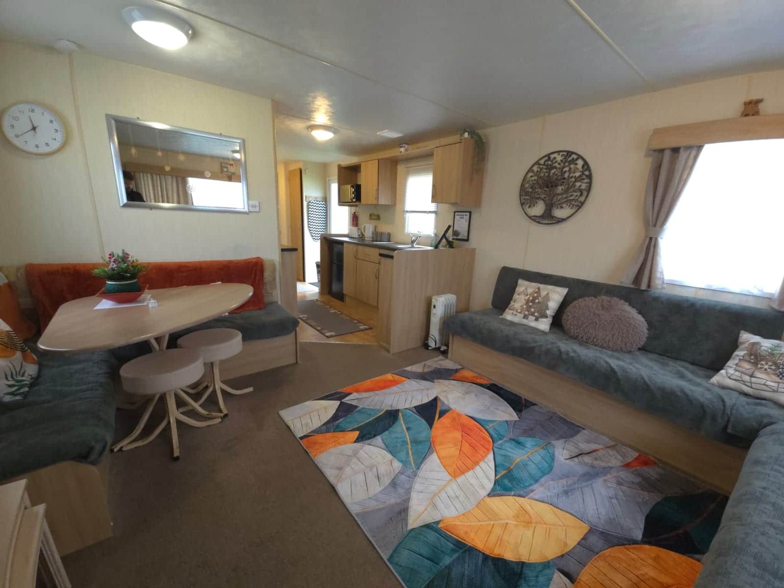 En kompakt bolig med tekøkken, spiseplads og sofa.