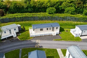 A residential area with multiple houses, a gated entrance, and a road. - The Retreat Anchorage – 8-Berth Caravan (Rhyl)