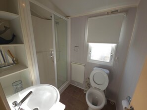 Ein Badezimmer mit Dusche, Toilette und Waschbecken.