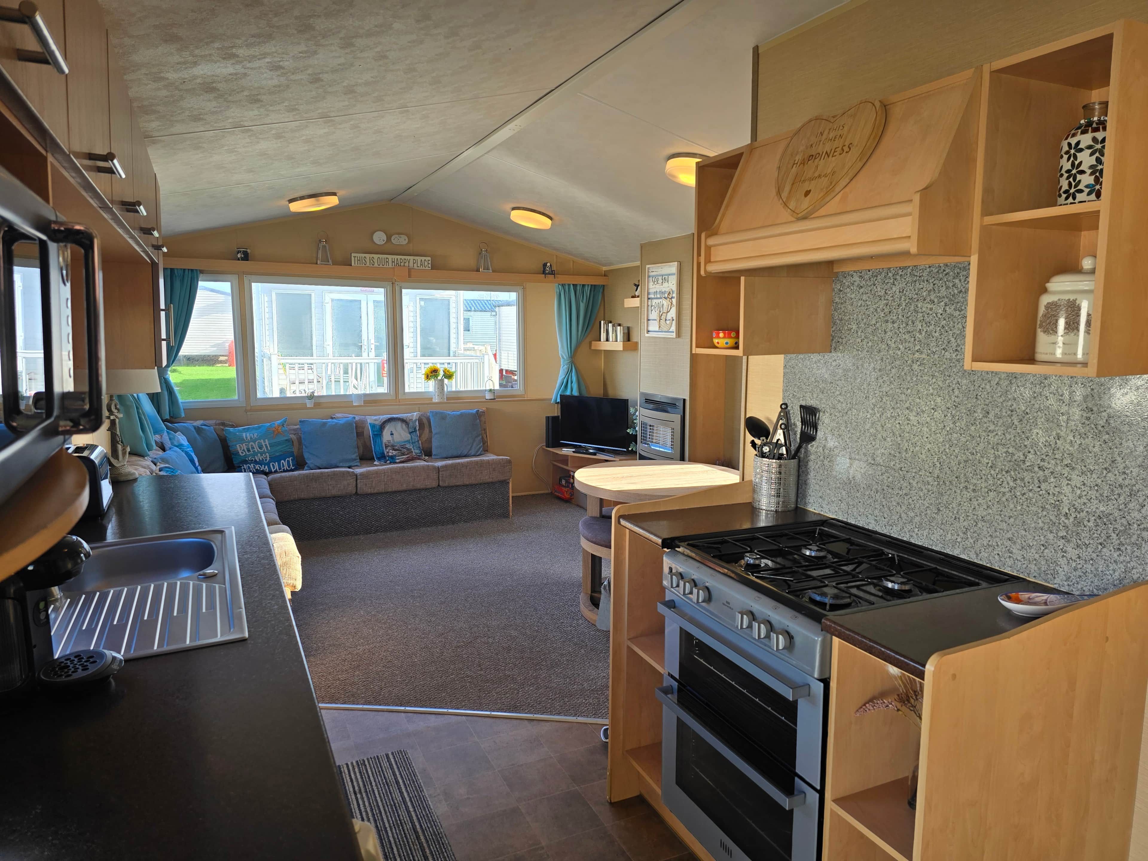 A compact RV kitchen with a stove, oven, and sink.