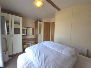 Ein Hotelzimmer mit Bett, Schreibtisch, Spiegel und Kleiderschrank.