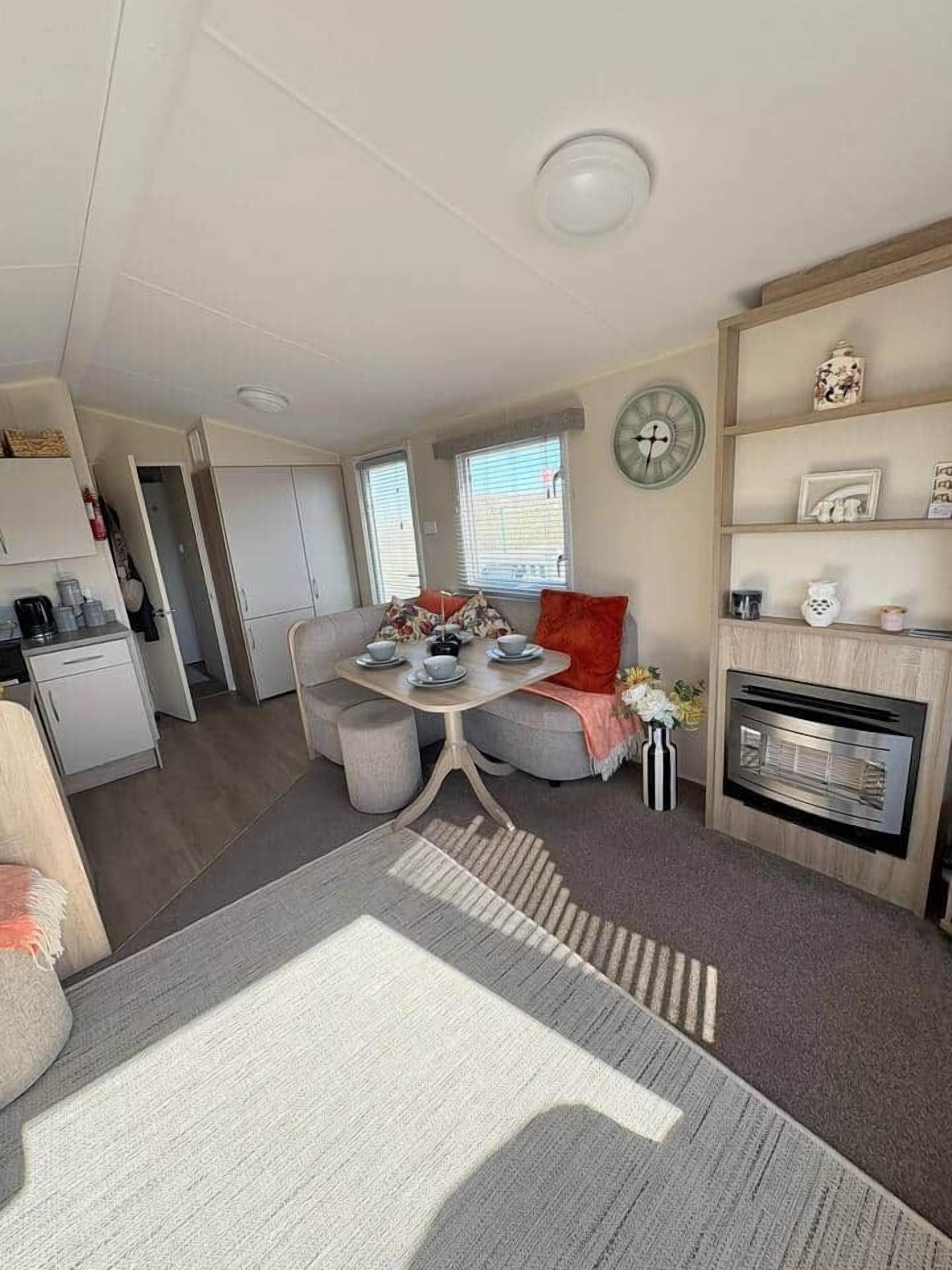 Un espace de vie compact comprenant une kitchenette, un coin repas et une cheminée.